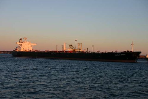 Cargo ship at a working port with cranes and water
