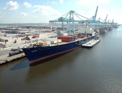 Cargo ship and port cranes representing maritime commerce