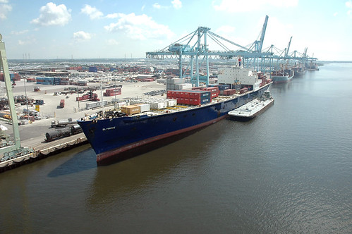 Cargo ship and port cranes representing maritime commerce