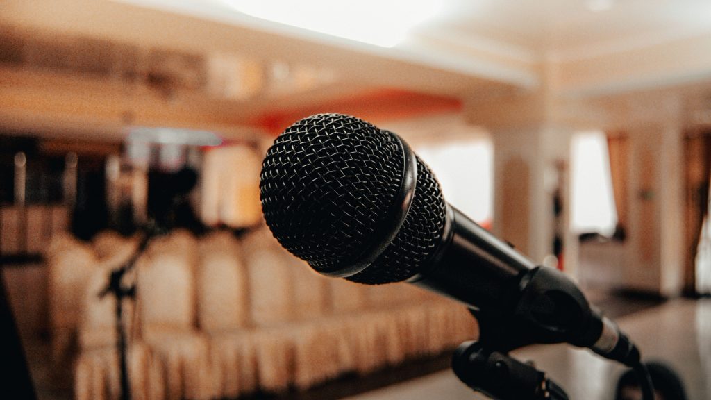 Illustrative stock photo of a microphone in an empty conference hall
