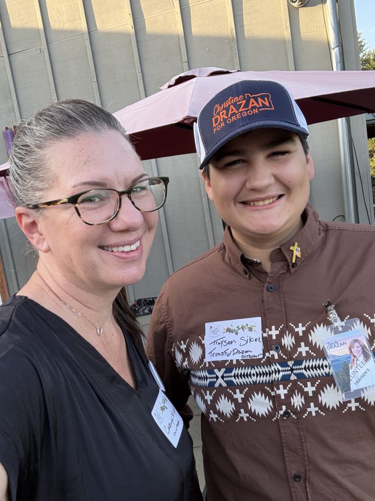 Two attendees taking a photo together at an outdoor gathering